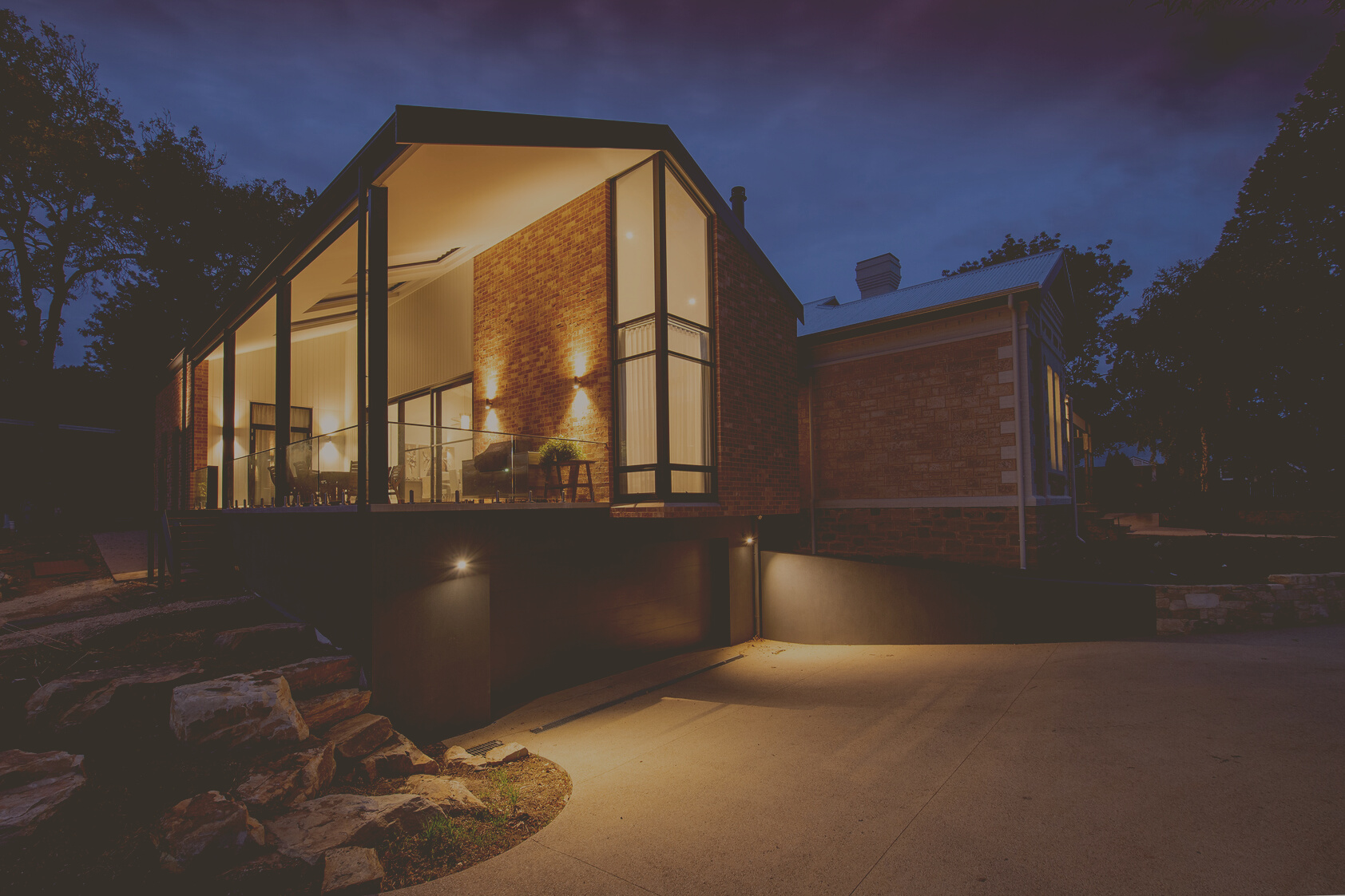 Modern house facade with glowing lights at dusk